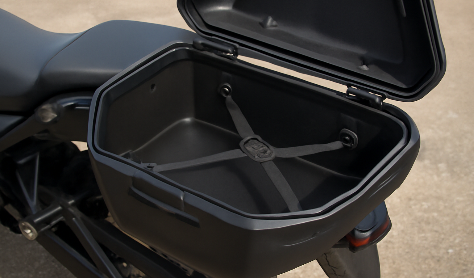 coffre moto ouvert montrant rangement intérieur