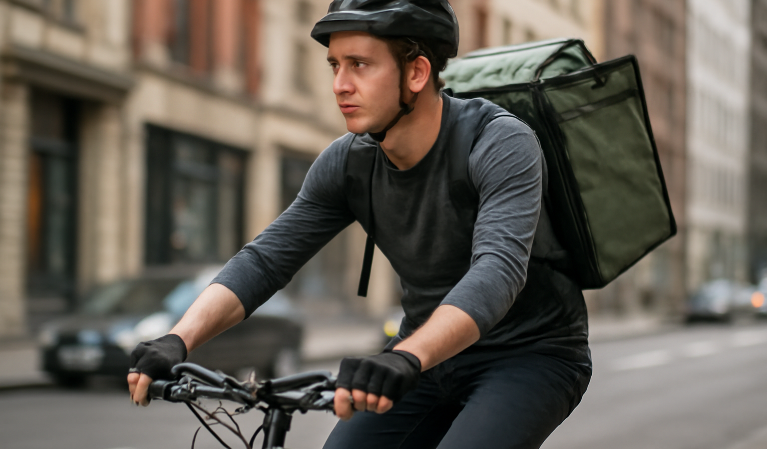 cycliste chargé effectuant une livraison urbaine
