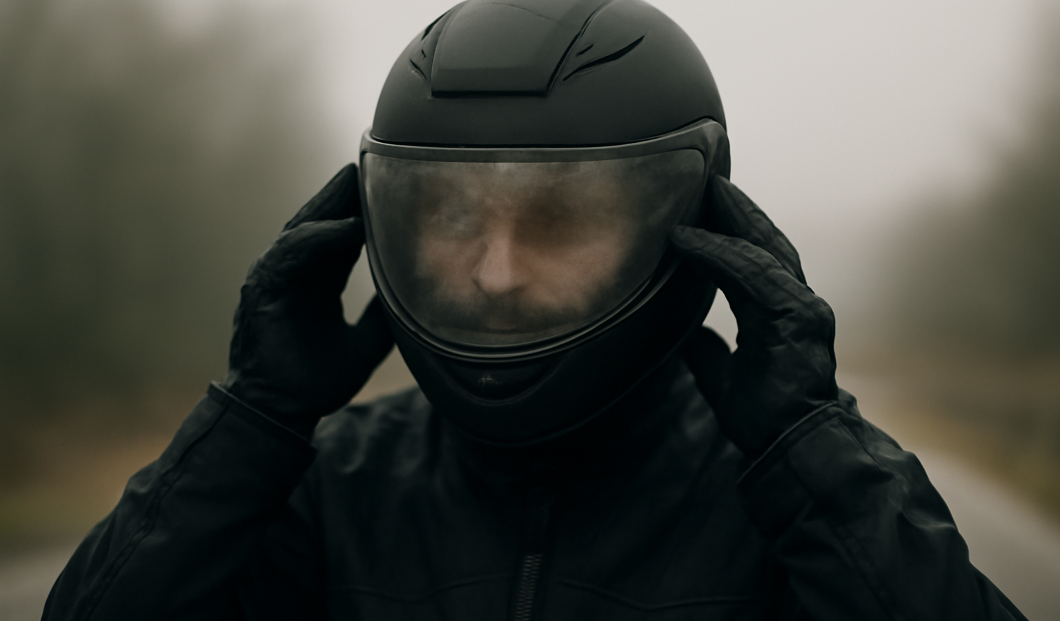motard ajustant son casque avec visière embuée