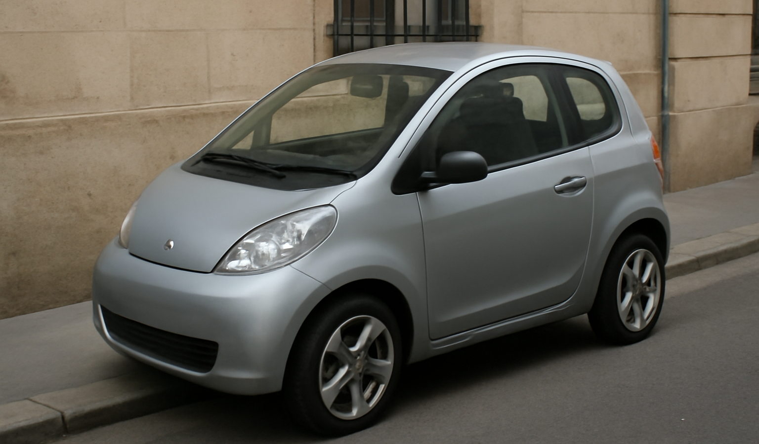 petite voiture électrique garée sur trottoir étroit