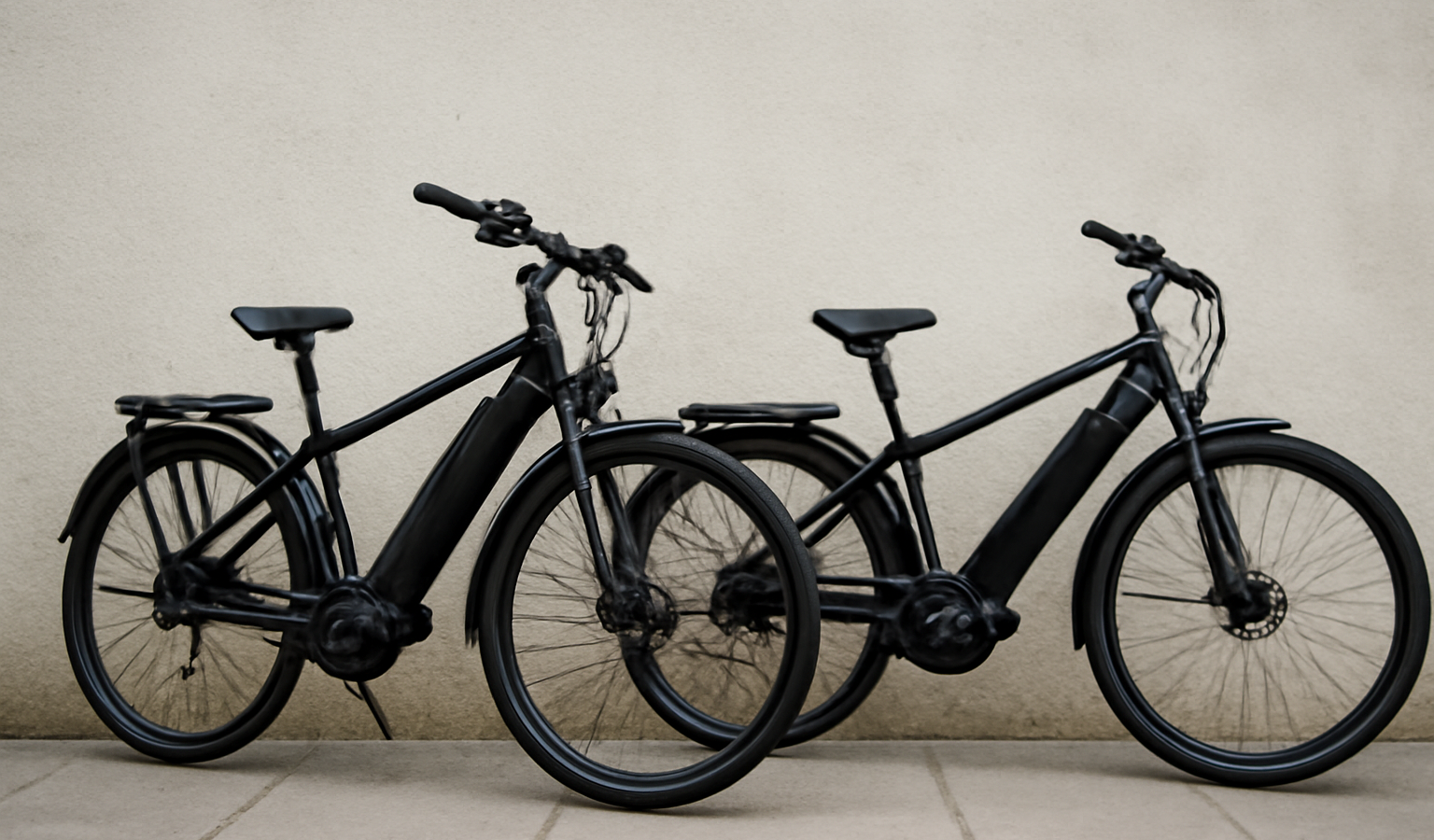 deux velos electriques appuyes contre un mur