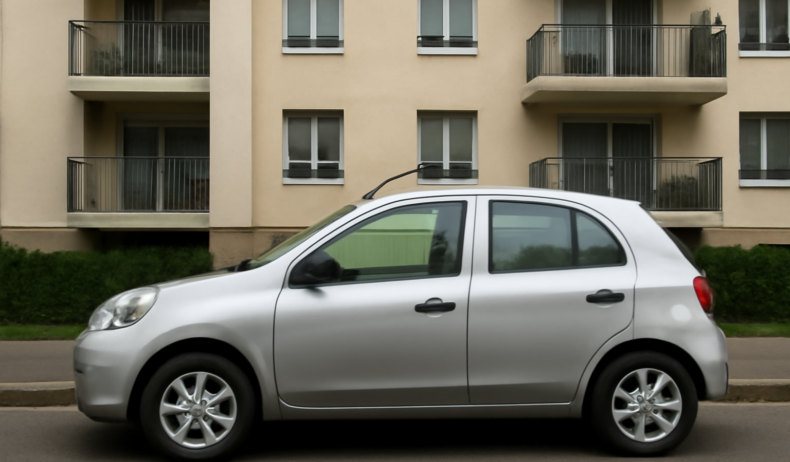 voiture compacte garee devant immeuble residentiel